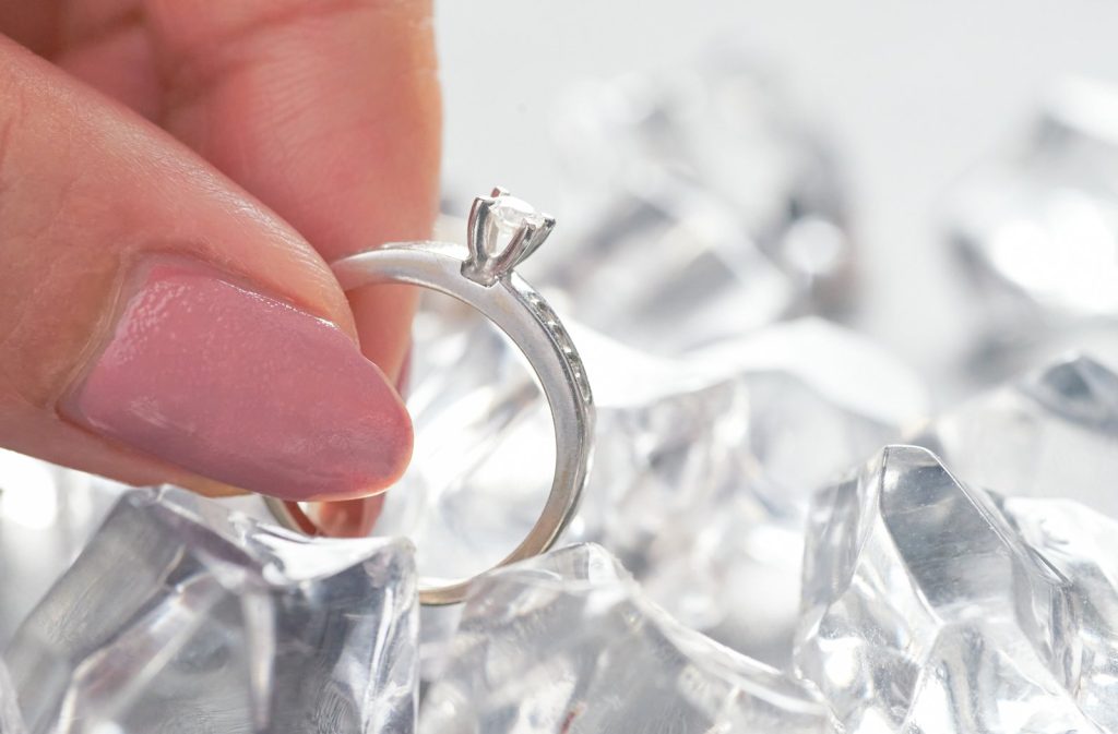 Close-up comparing engagement ring settings: claw, halo and bezel diamond rings