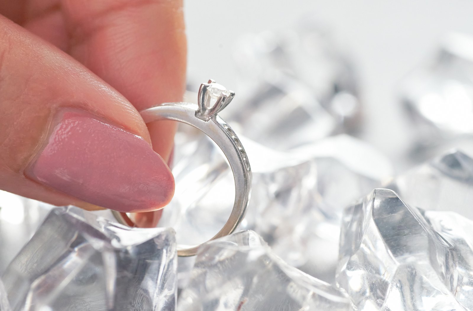 Close-up comparing engagement ring settings: claw, halo and bezel diamond rings